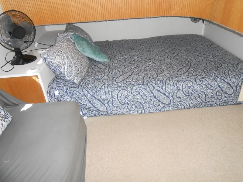 Slide: The Image of Cozy bedroom in 1990 Skipperliner Custom Houseboat with patterned bedding and a small fan. - 22