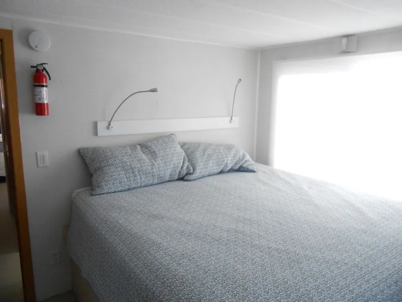 Slide: The Image of Cozy bedroom in 1990 Skipperliner Custom Houseboat with patterned bedding and wall-mounted reading lights. - 25