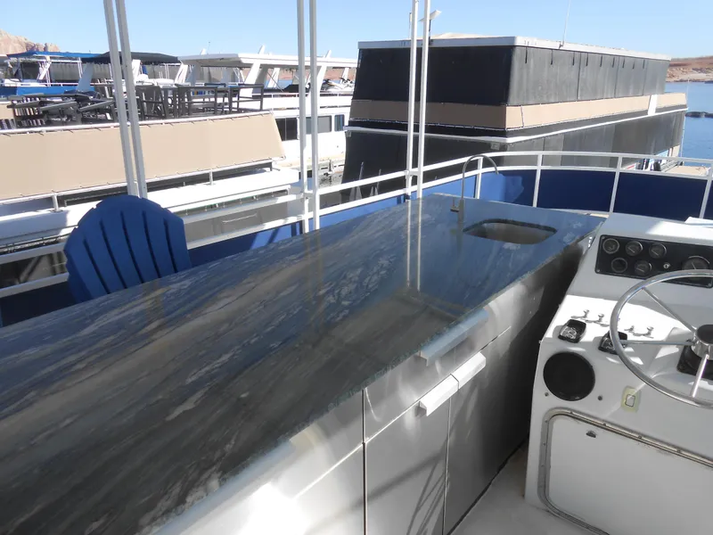Slide: The Image of 1990 Skipperliner Custom Houseboat helm with sleek countertop and steering wheel. - 4