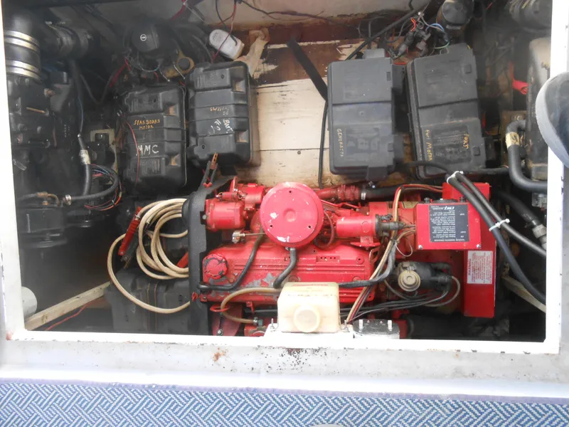 Slide: The Image of Engine compartment of a 1990 Skipperliner Custom Houseboat, featuring a red engine and wiring. - 7