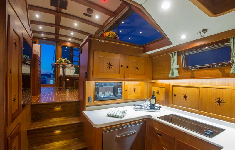 Slide: The Image of 2024 Lyman-Morse HUNT Express Cruiser Flybridge at sunset, showcasing elegant deck and illuminated interior. - 14