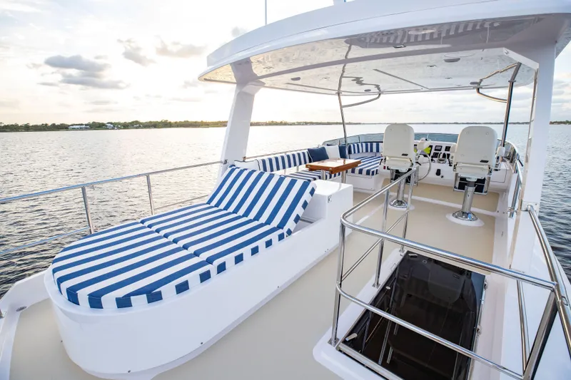 Slide: The Image of Luxurious 2025 Summit 54 yacht with striped sun loungers and spacious deck. - 11