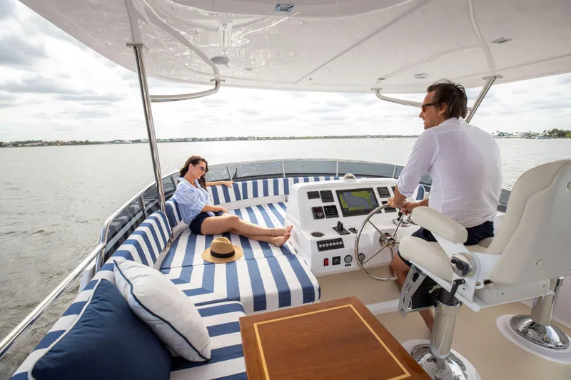 Slide: The Image of Couple enjoying a day on a 2025 Summit 54 yacht, relaxing on striped cushions. - 12