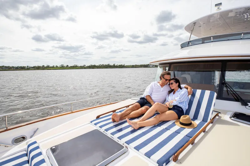 Slide: The Image of Couple relaxing on a 2025 Summit 54 yacht with striped lounge chairs. - 13