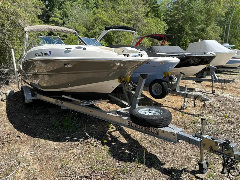 Slide: The Image of 2016 Stingray 234 LR boat on trailer, parked outdoors with other boats nearby. - 37