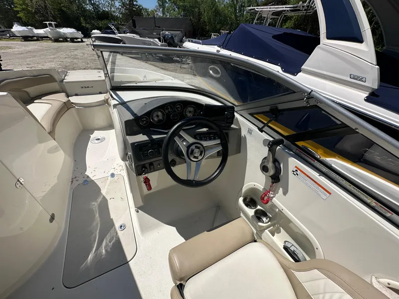 Slide: The Image of 2016 Stingray 234 LR boat interior with steering wheel and seating. - 45