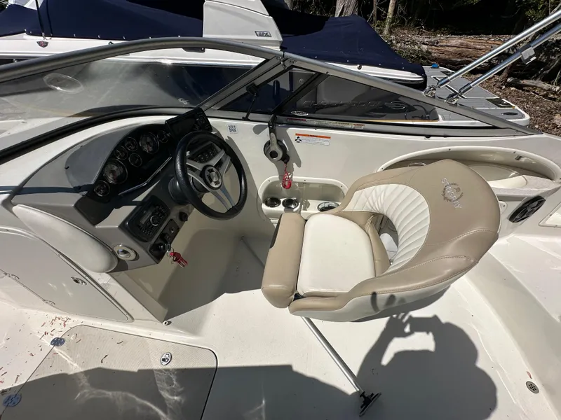 Slide: The Image of 2016 Stingray 234 LR boat cockpit with steering wheel and beige seating. - 46