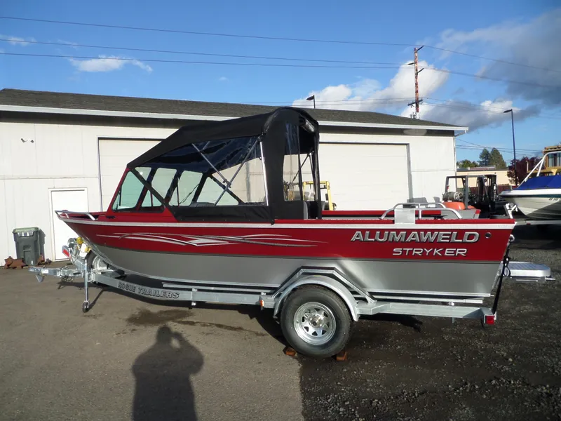 Slide: The Image of 2018 Alumaweld Stryker boat on a Rogue Trailer, parked outside a building. - 9