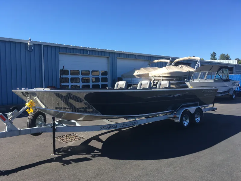 Slide: The Image of 2018 Alumaweld Super Vee Pro boat on a Rogue trailer outside a blue warehouse. - 10