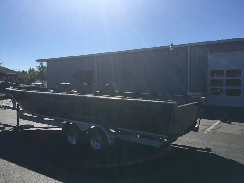 Slide: The Image of 2018 Alumaweld Super Vee Pro boat on a trailer outside a metal building. - 6