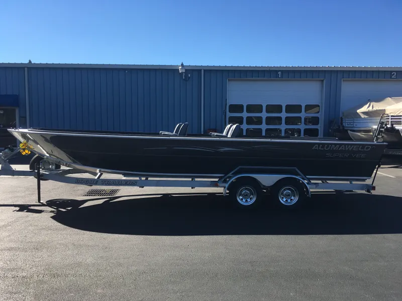 Slide: The Image of 2018 Alumaweld Super Vee Pro boat on Rogue Trailer in front of a blue building. - 8