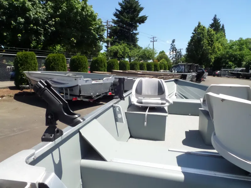 Slide: The Image of 2017 Smoker Craft Alaskan boat in a parking lot with trees in the background. - 12