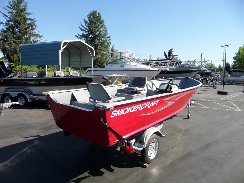 Slide: The Image of 2017 Smoker Craft Alaskan boat in red on a trailer at a marina. - 2