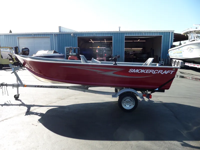 Slide: The Image of 2017 Smoker Craft Alaskan boat on EZ Loader trailer in front of blue storage units. - 5