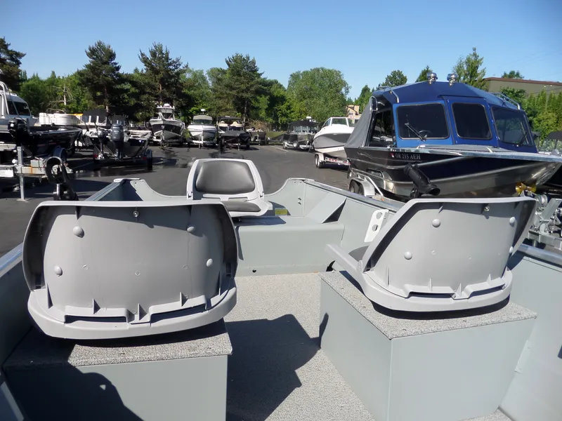 Slide: The Image of 2017 Smoker Craft Alaskan boat interior with seating, parked among other boats. - 9