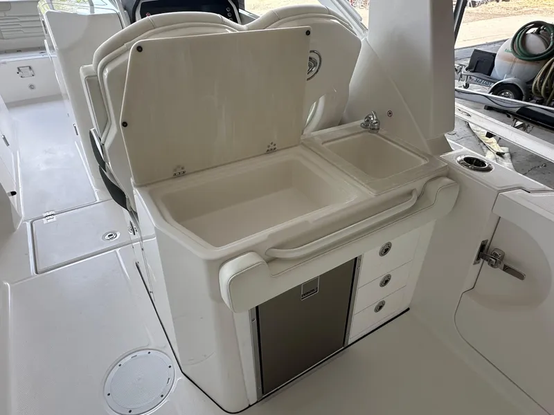 Slide: The Image of 2026 Edgewater 262CX Crossover boat interior with sink and storage compartments. - 19