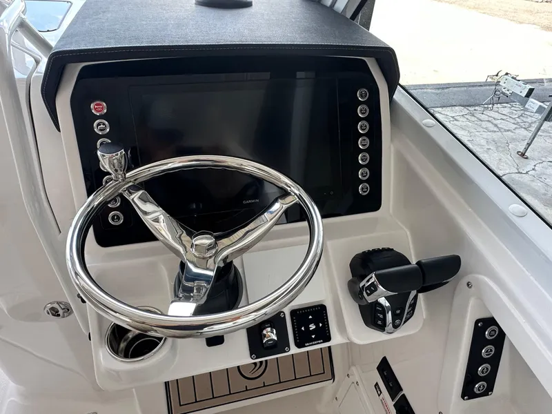 Slide: The Image of 2026 Edgewater 262CX Crossover boat dashboard with steering wheel and control panel. - 25