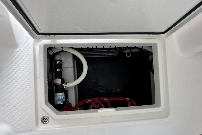 Slide: The Image of Open storage compartment in 2026 Edgewater 262CX Crossover boat, showing internal components. - 36