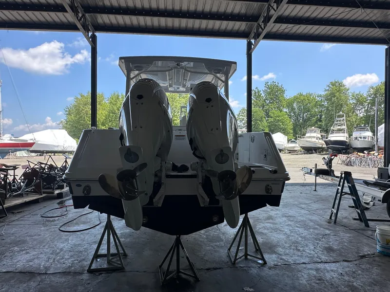 Slide: The Image of 2026 Edgewater 262CX Crossover boat with dual engines in a marina storage area. - 5
