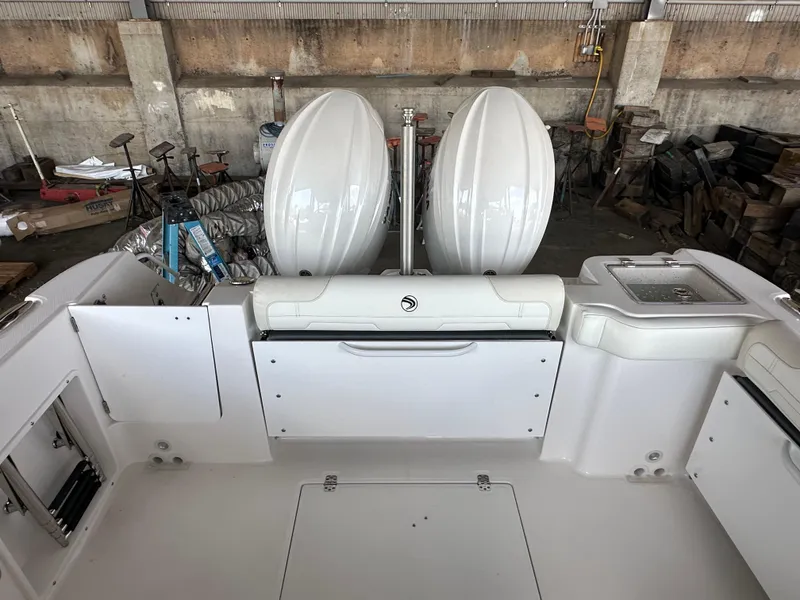 Slide: The Image of 2026 Edgewater 262CX Crossover boat interior with dual engines in a storage facility. - 9