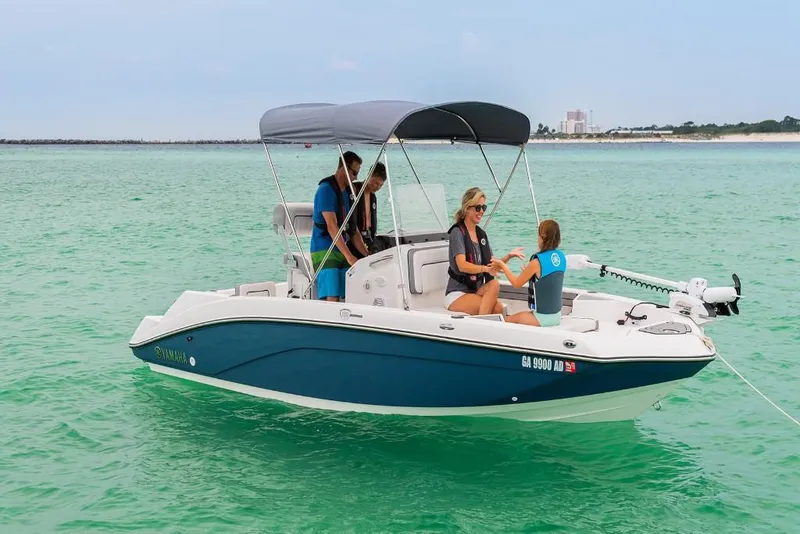 Slide: The Image of 2023 Yamaha Boats 190 FSH Deluxe on clear water with passengers. - 5