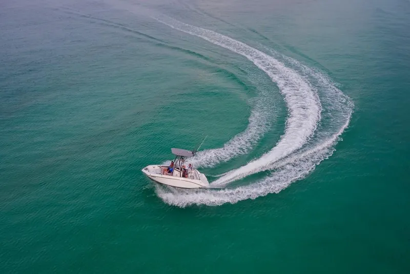 Slide: The Image of Aerial view of 2023 Yamaha Boats 190 FSH Sport cruising on clear water. - 8