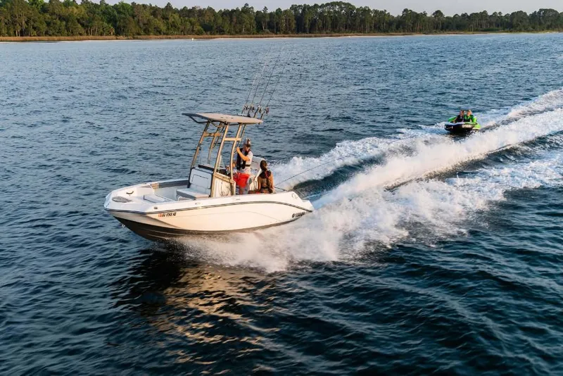Slide: The Image of 2023 Yamaha Boats 190 FSH Sport cruising on a lake with people onboard. - 9