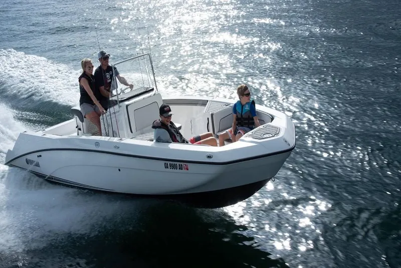 Slide: The Image of 2023 Yamaha Boats 210 FSH cruising on water with passengers. - 2