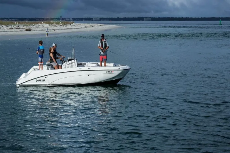 Slide: The Image of 2023 Yamaha Boats 210 FSH on water with three people fishing. - 3