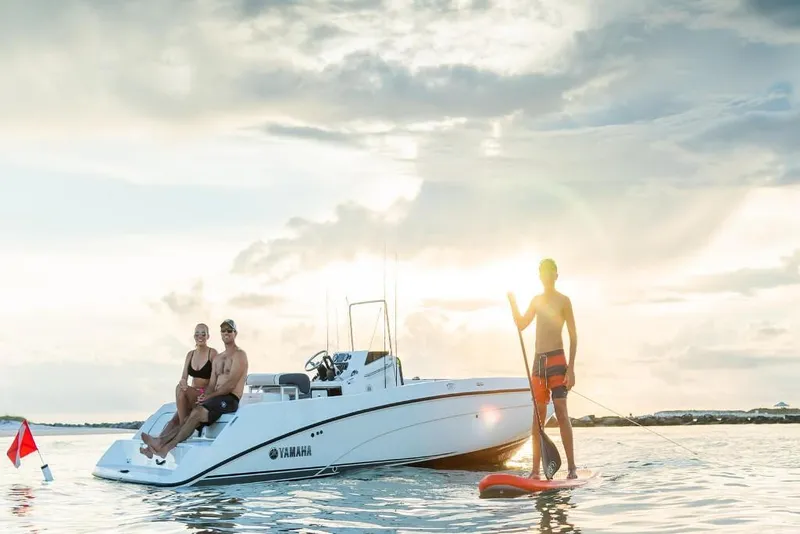 Slide: The Image of 2023 Yamaha Boats 210 FSH with people enjoying water activities at sunset. - 5
