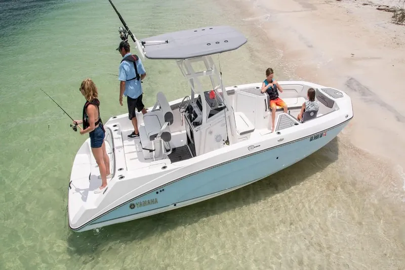 Slide: The Image of 2023 Yamaha Boats 210 FSH Sport on clear water near sandy beach. - 1