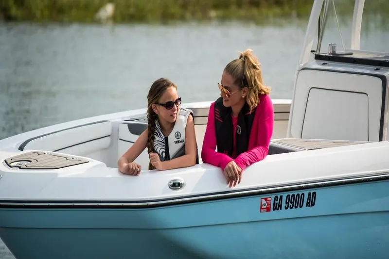Slide: The Image of 2023 Yamaha Boats 210 FSH Sport on water with two people enjoying. - 5