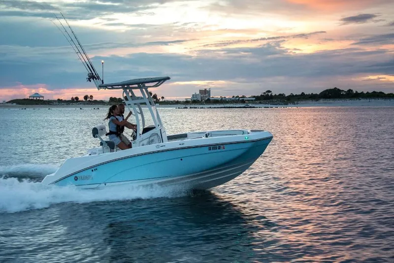 Slide: The Image of 2023 Yamaha Boats 210 FSH Sport cruising at sunset on calm waters. - 7