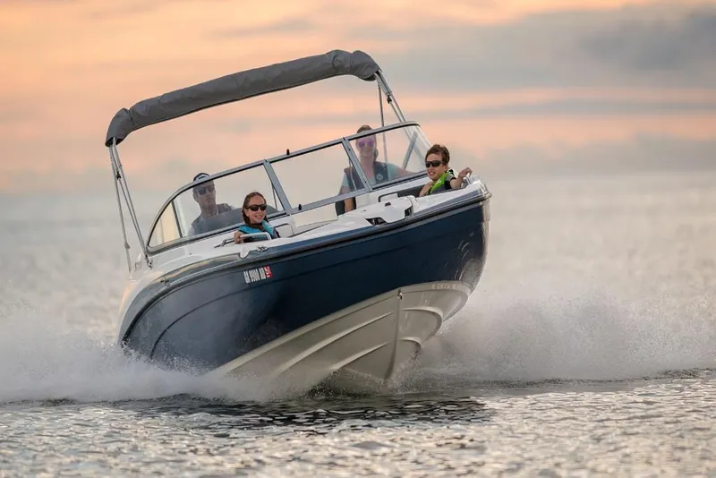 Slide: The Image of 2023 Yamaha Boats SX210 cruising on water at sunset. - 4