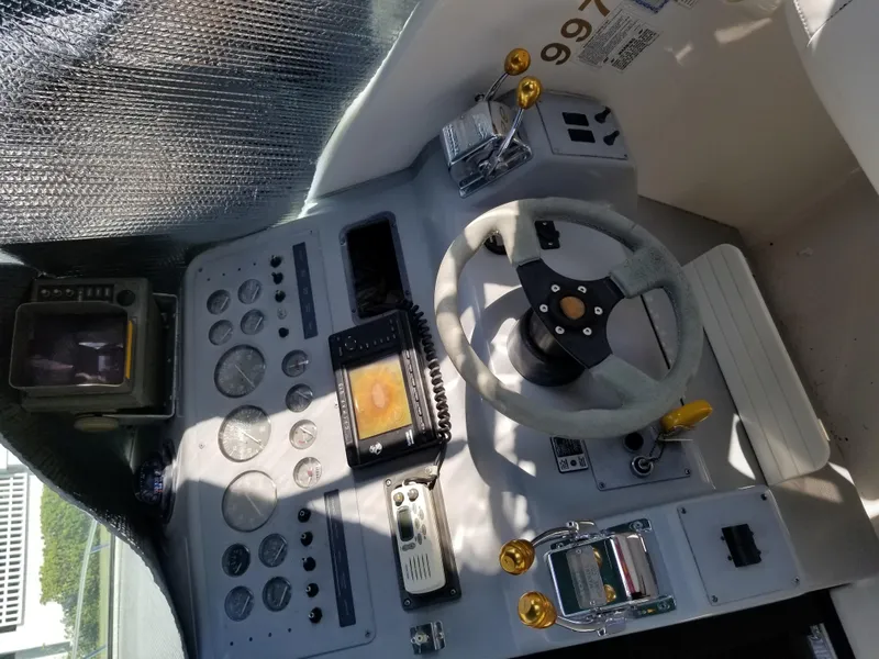 Slide: The Image of 1993 Tiara Yachts 270 Sport Cruiser helm with steering wheel and navigation instruments. - 13