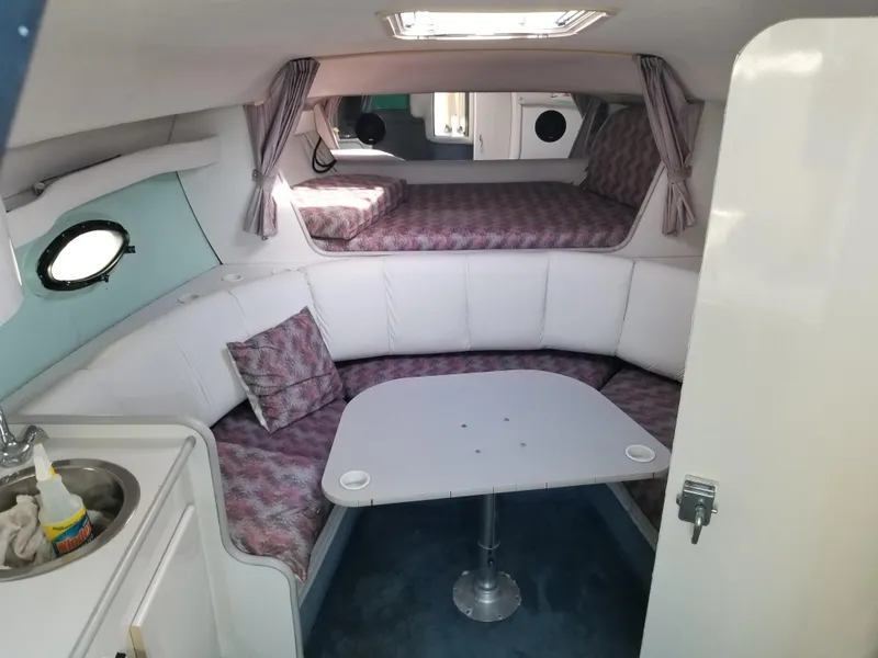 Slide: The Image of 1993 Tiara Yachts 270 Sport Cruiser cabin interior with seating, table, and bed. - 2
