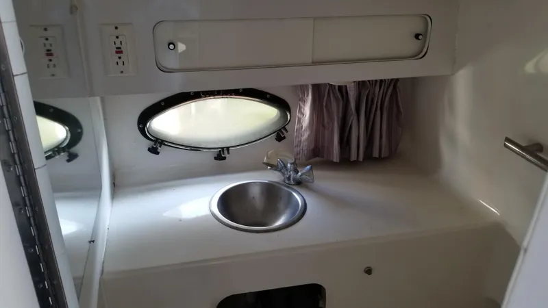 Slide: The Image of 1993 Tiara Yachts 270 Sport Cruiser interior sink area with porthole window. - 23