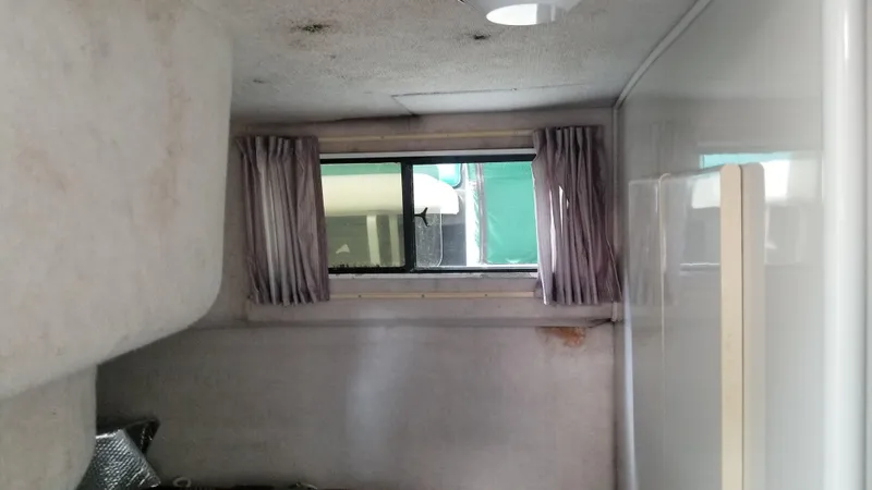 Slide: The Image of Interior cabin of a 1993 Tiara Yachts 270 Sport Cruiser with window and curtains. - 34