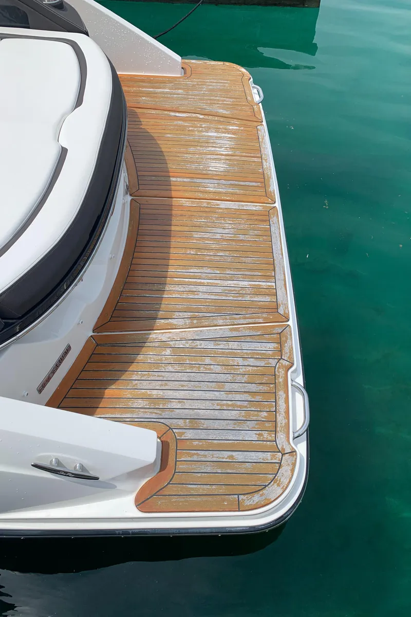 Slide: The Image of 2018 Sea Ray SLX 310 boat deck with teak flooring and white seating. - 35