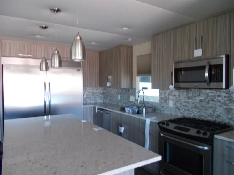 Slide: The Image of Modern kitchen in 2016 Adonia Titan Trip 9, featuring stainless steel appliances and pendant lighting. - 12