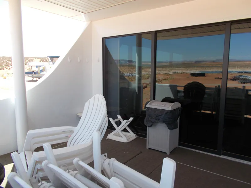 Slide: The Image of Outdoor patio with white chairs, glass doors, and scenic desert view. Adonia Titan Trip 9, 2016. - 7