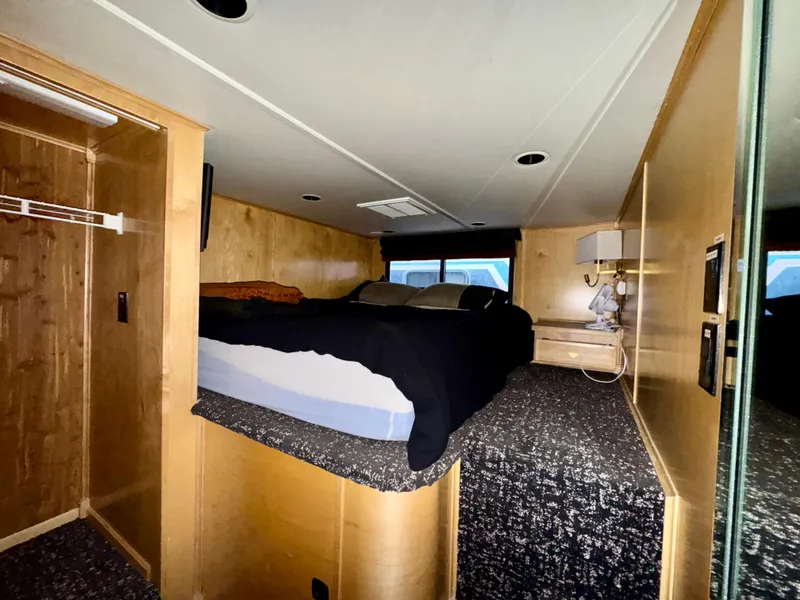 Slide: The Image of Interior of 2008 Sumerset Waterways Houseboat bedroom with bed, wooden walls, and carpeted floor. - 11