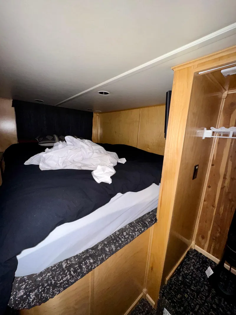 Slide: The Image of Cozy bedroom in 2008 Sumerset Waterways Houseboat with unmade bed and wooden interior. - 14