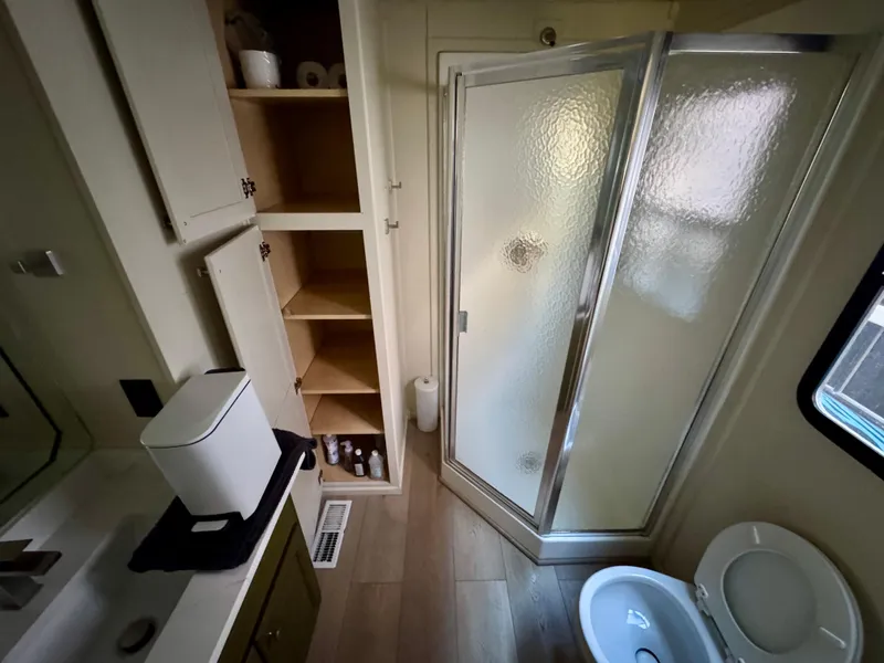 Slide: The Image of 2008 Sumerset Waterways houseboat bathroom with shower, toilet, and storage shelves. - 19