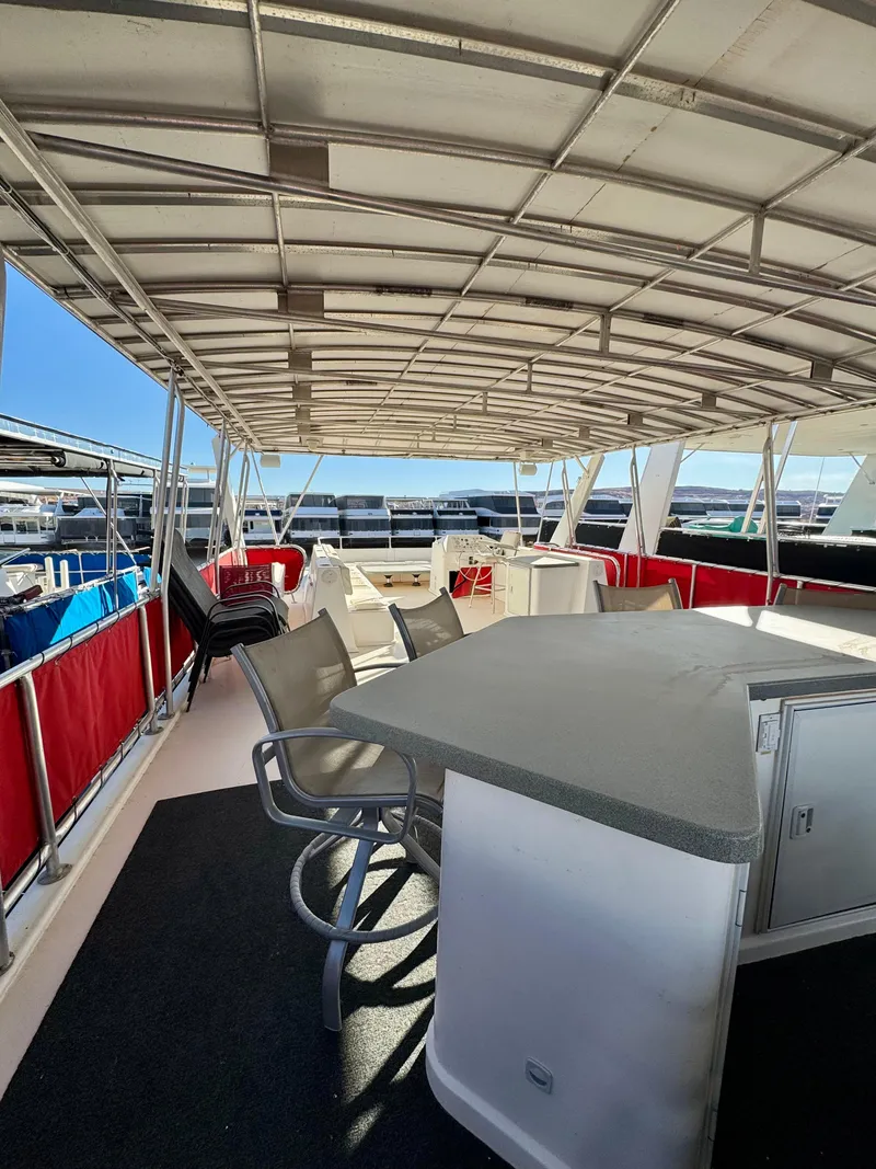 Slide: The Image of 2008 Sumerset Waterways Houseboat interior with seating and bar, featuring a covered deck. - 25