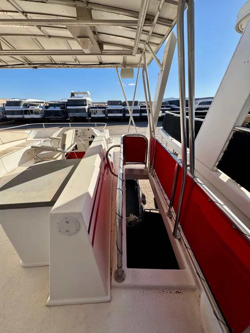 Slide: The Image of 2008 Sumerset Waterways Houseboat deck with red seating, docked at marina. - 27