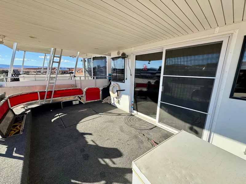 Slide: The Image of 2008 Sumerset Waterways Houseboat deck with red seating and sliding glass door. - 29