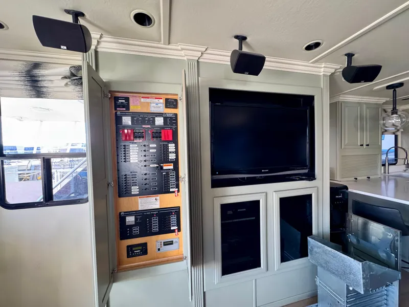 Slide: The Image of Interior of 2008 Sumerset Waterways Houseboat with control panel and TV setup. - 3