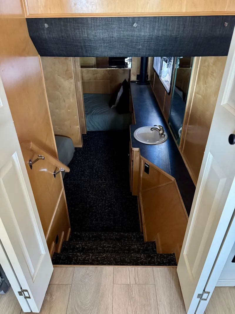 Slide: The Image of Interior of 2008 Sumerset Waterways Houseboat with stairs, sink, and cozy sleeping area. - 9