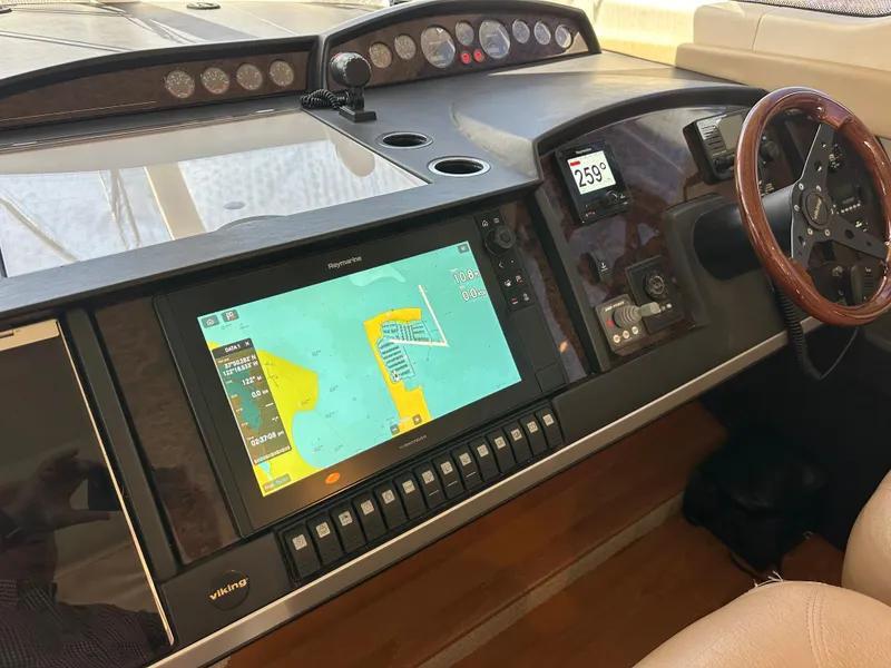 Slide: The Image of Interior view of a 2007 Viking Sport Cruiser yacht, featuring elegant seating and a scenic outdoor view. - 16